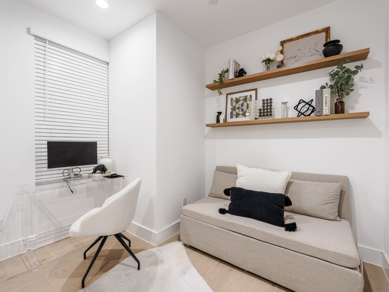 A bright, modern room with a comfy sofa bed and a dedicated workspace—perfect for relaxing or getting work done.