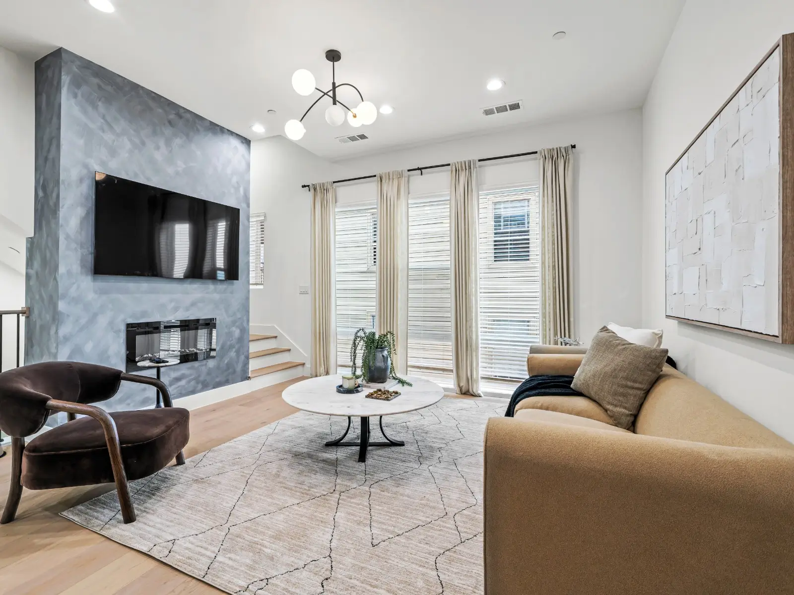 A modern room with a large TV, electric fireplace, and comfy seating—perfect for unwinding after a long day.