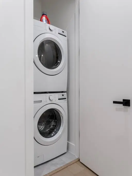 A stacked washer and dryer tucked neatly into a closet for easy, on site laundry during your stay.